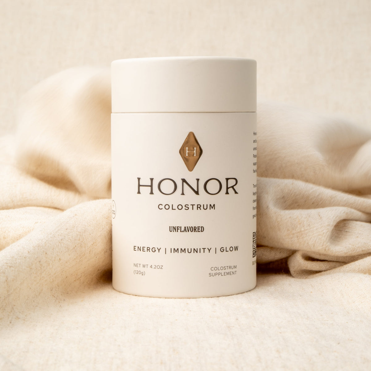 Honor Colostrum tube on a linen backdrop