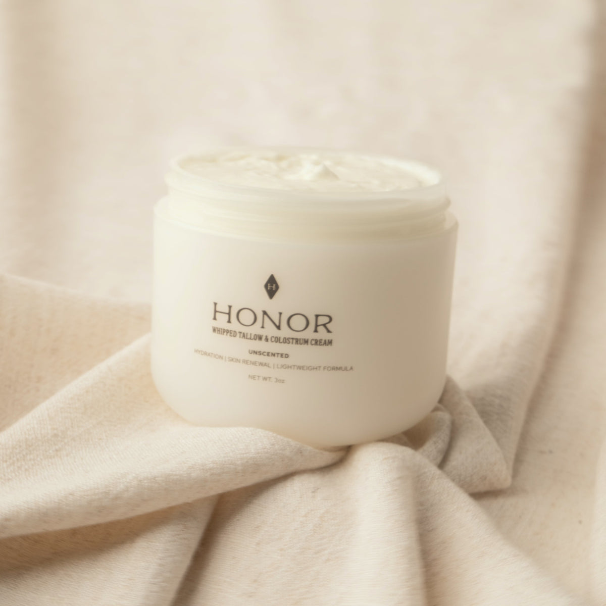 Open jar of Honor Whipped Tallow & Colostrum Cream